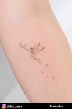 a small tattoo on the arm of a woman's left arm, with a tiny fairy