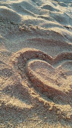 a heart drawn in the sand on a beach