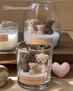 three candles with teddy bears in them on a table