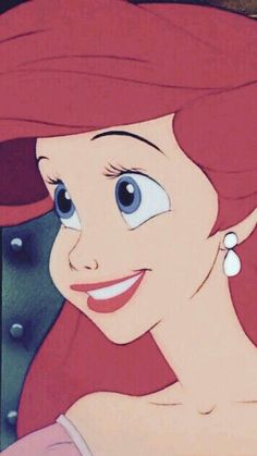 ariel from the little mermaid with big blue eyes and pink hair, smiling at the camera