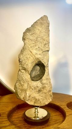 a rock with a hole in it on a stand