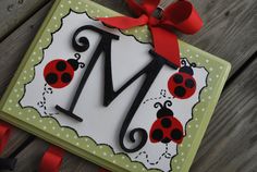 a card with ladybugs on it and the letter m is made out of paper