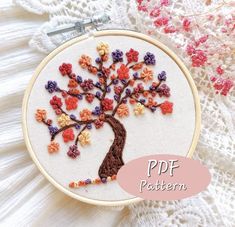 an embroidered tree with colorful flowers on it