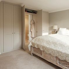 a large white bed sitting in a bedroom next to a closet