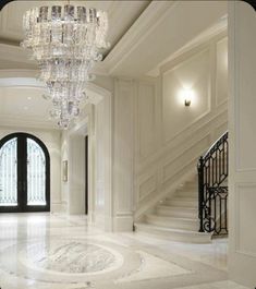 an elegant foyer with chandelier and marble floors