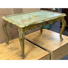 an old table is painted green and gold