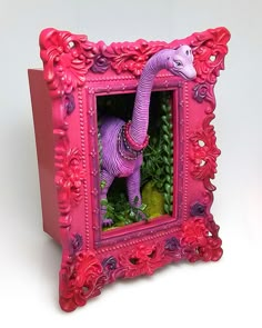 a pink frame with a purple dinosaur in the center and flowers on the outside, inside