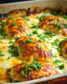 a casserole dish with chicken and cheese covered in parsley on the side