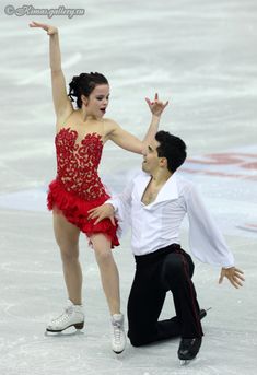 a man and woman skating on ice with one holding the other's hand up