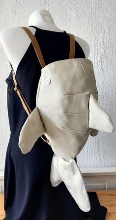 a mannequin wearing a white bag with a fish on it's back