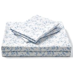 two sheets with blue flowers on them and one sheet is folded in front of the other