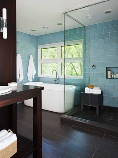 a bathroom with blue walls and wood floors, along with a large tub in the corner