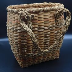 a woven basket with rope handles on a blue background