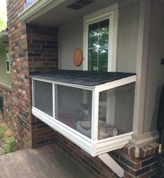 an open window on the side of a house with a dog laying in it's bed