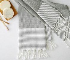 a gray and white striped towel next to two bowls with spoons