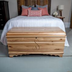 a bed sitting next to a wooden chest on top of a carpeted bedroom floor