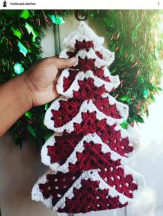 a crocheted christmas tree ornament hanging on a door