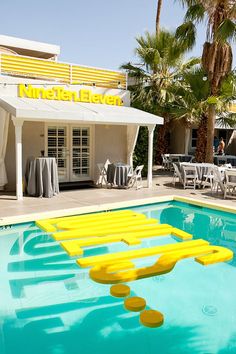 an empty swimming pool with chairs and tables in front of the building that houses nineteen eleven