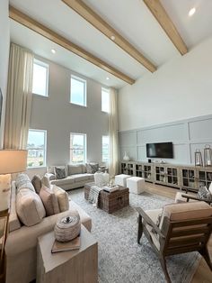 a living room filled with lots of furniture and large windows above the couches in front of them