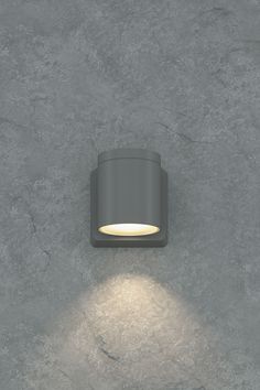 an outdoor wall light on the side of a concrete wall with a white light coming from it