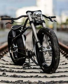 a black motorcycle parked on top of train tracks