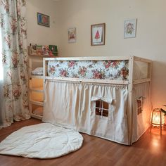 a child's room with a bed and rug on the floor next to a window