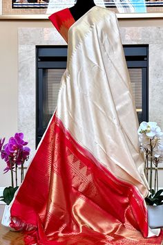 This stunning kanjivaram saree is handwoven in tussar white woven in ettu kol technique. The borders have an ettu kol temple reku woven in gold zari. The grand pallu in vermilion red color features an ettu kol band in gold zari bordering with peacocks and traditional motifs. Approximate Length 6.5 mtrs (inclusive of blouse length) Approximate Height - 48 - 52" Approximate weight - 1.7 lbs Saree comes with fall, picot and tassels done when applicable. Blouse piece is cut. Kindly Note : The colors you see on your device may vary due to the color reproduction, brightness and resolution of individual devices. If you'd like more clarity before your purchase, please contact our support team. Vermilion Red, Kanjivaram Saree, Kanjivaram Silk Saree, Kanjivaram Sarees, Traditional Motifs, Blouse Length, Peacocks, Support Team, Cotton Saree