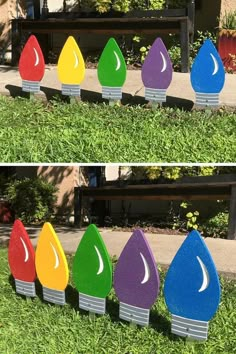 three different colored raindrops sitting in the grass