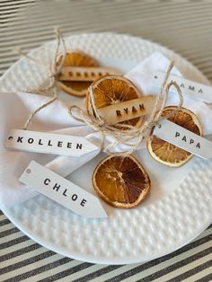 some oranges are sitting on a plate with name tags