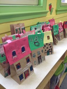 small paper houses are lined up on the table