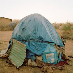 there is a blue tarp over the top of a tent in the middle of nowhere