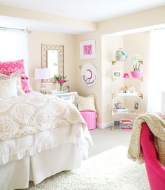 a bedroom with pink accents and white bedding