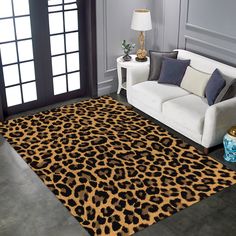 a living room with a couch, chair and leopard print rug