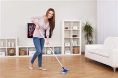 a woman is cleaning the floor with a mop