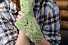 a woman with red hair wearing green knitted mittens and looking at the camera