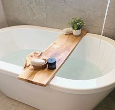 a bathtub with a wooden tray on the side