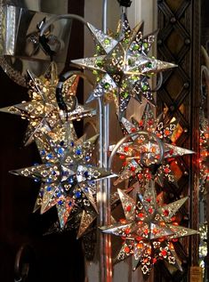 several christmas decorations hanging from a pole in front of a mirror wall with lights on it