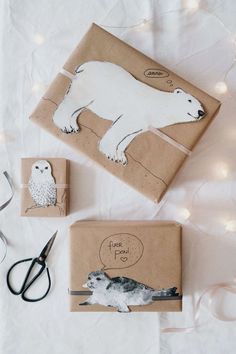 wrapping paper with polar bear and owl on it next to scissors, string lights and other items