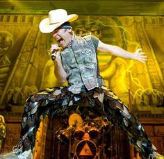 a man with a cowboy hat is performing on stage