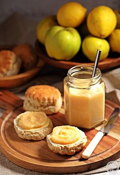 there is a jar of peanut butter next to some lemons and bread on a plate