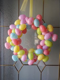 a wreath made out of balloons hanging on the front door