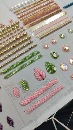 some pink and green beads are on a piece of paper