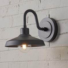 a light that is on the side of a wall next to a white brick wall