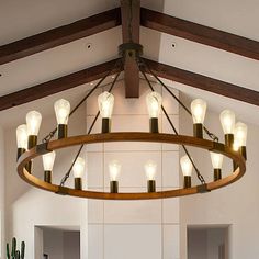 a chandelier hanging from the ceiling in a room with white walls and wood beams