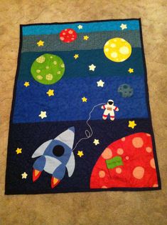 a child's rug with an image of space and rockets on it