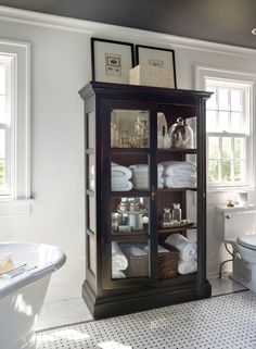 a bathroom with a toilet, sink and cabinet in it's centerpieces