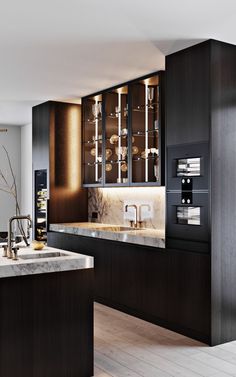 a modern kitchen with black cabinets and marble counter tops