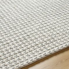 a white rug on top of a wooden floor