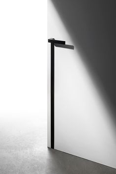 an open door with a black handle on the side and light coming in from behind it