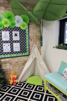 a teepee tent in the corner of a room with green decorations on the wall